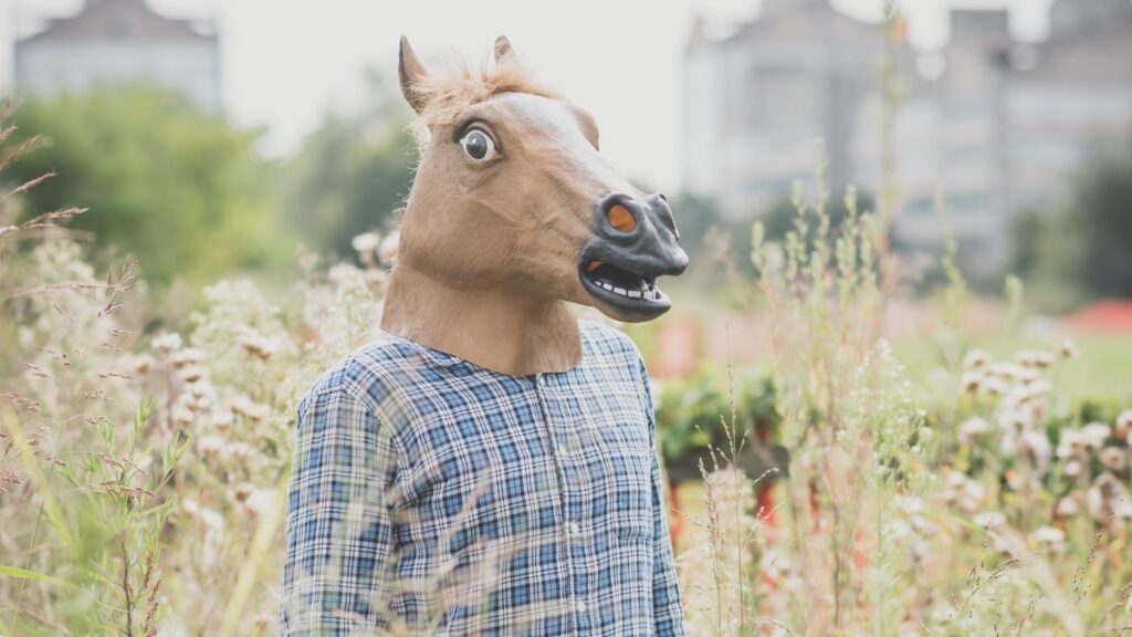 Maskering af autisme symboliseret af person med hestemaske, der ser anspændt ud